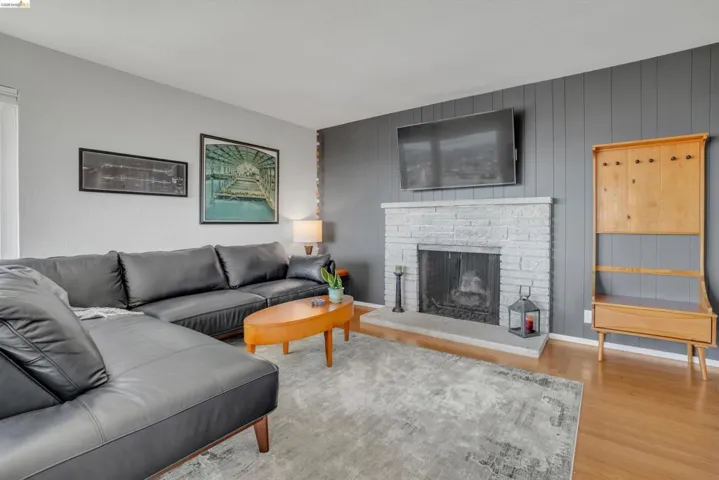 Living room featuring a fireplace with raised hearth and wood finished floors