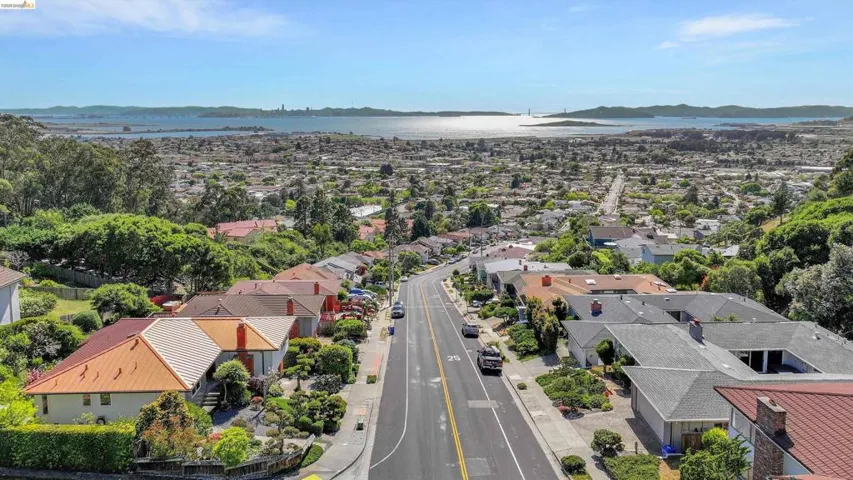 Aerial perspective of suburban area featuring a nearby body of water