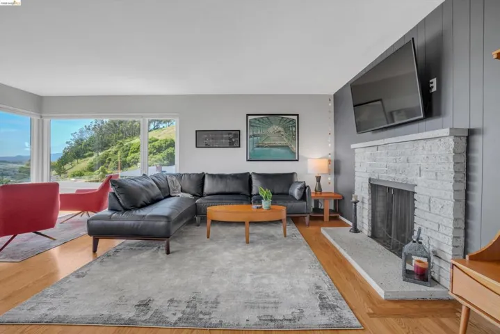 Living area with light wood-style flooring and a brick fireplace