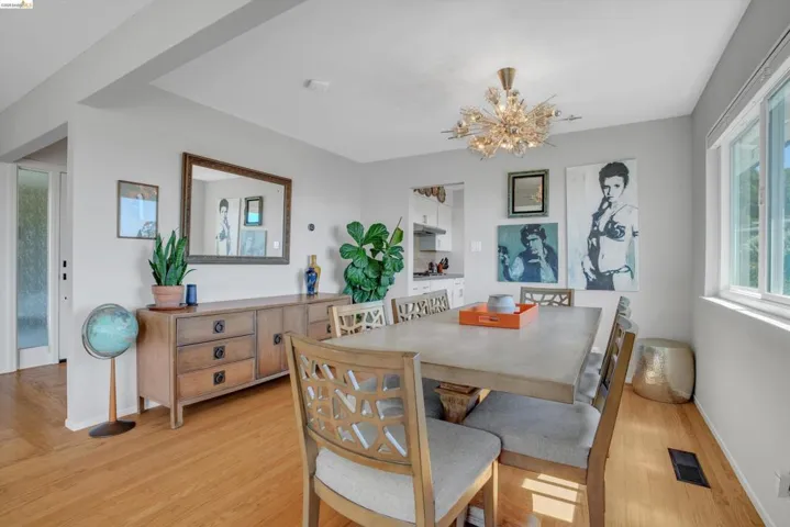 Dining room with light wood-style floors and suspended lighting