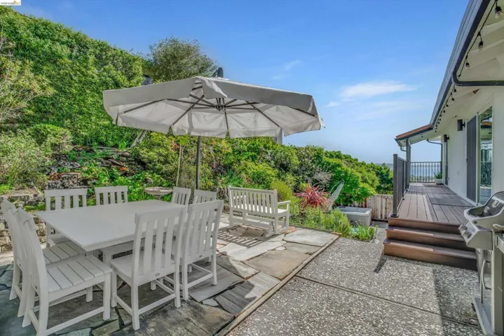 View of patio / terrace featuring a wooden deck, outdoor dining area, and a grill
