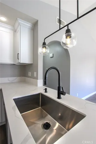 Remodeled kitchen with new countertops, cabinets, stainless sink, faucet and lighting.