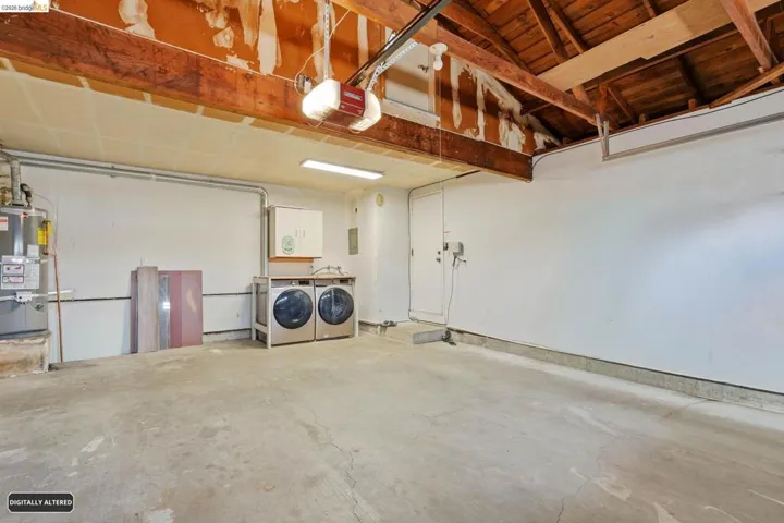 Garage with secured water heater, a garage door opener, and washing machine and dryer