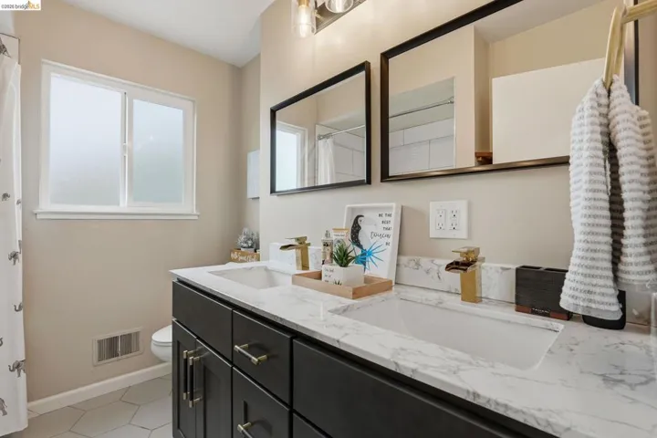 Full bathroom featuring double vanity and curtained shower