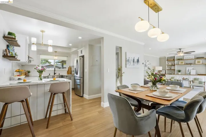 Dining room featuring light wood-style floors, ornamental molding, ceiling fan, and built in shelves