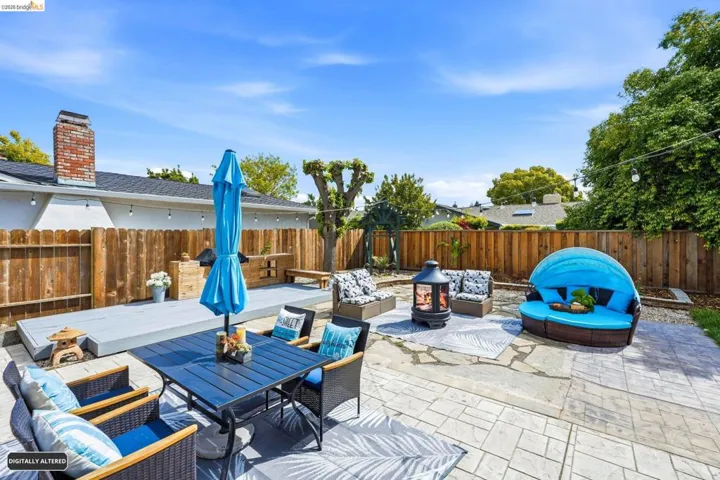 Fenced backyard with an outdoor living space with a fire pit and a patio