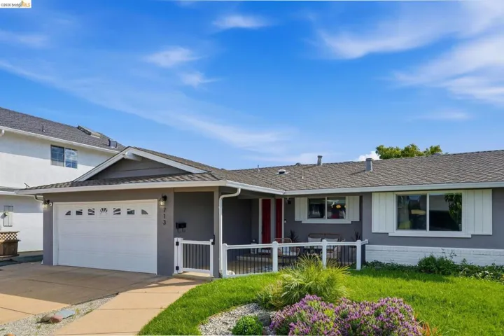 Ranch-style house featuring a garage, concrete driveway, roof with shingles, and stucco siding