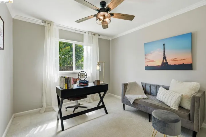 Office area featuring crown molding, carpet, and a ceiling fan
