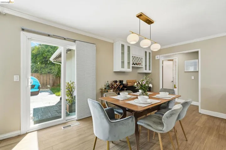 Dining room with light wood finished floors and ornamental molding