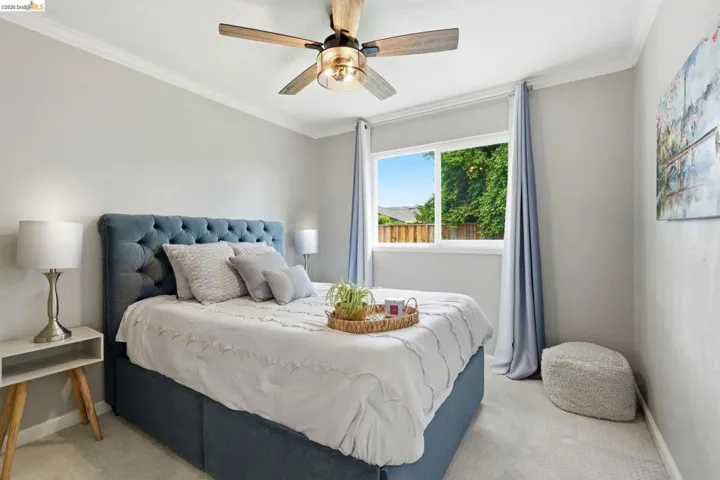 Bedroom featuring crown molding, light colored carpet, and a ceiling fan