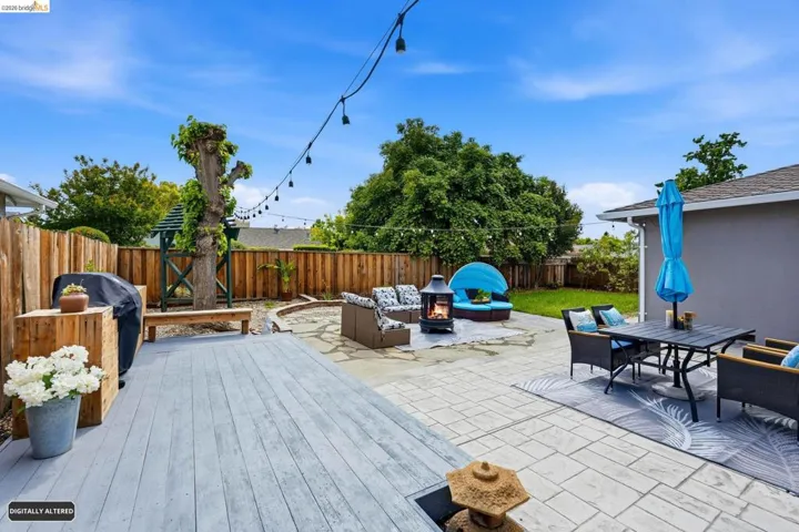 Fenced backyard featuring a fire pit, area for grilling, a patio area, outdoor lounge area, and a wooden deck