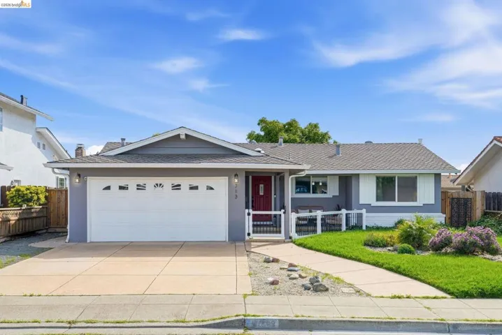 Single story home with a garage, driveway, a shingled roof, and brick siding