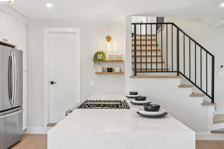 Kitchen with stainless steel appliances, light stone counters, recessed lighting, and light wood-style flooring