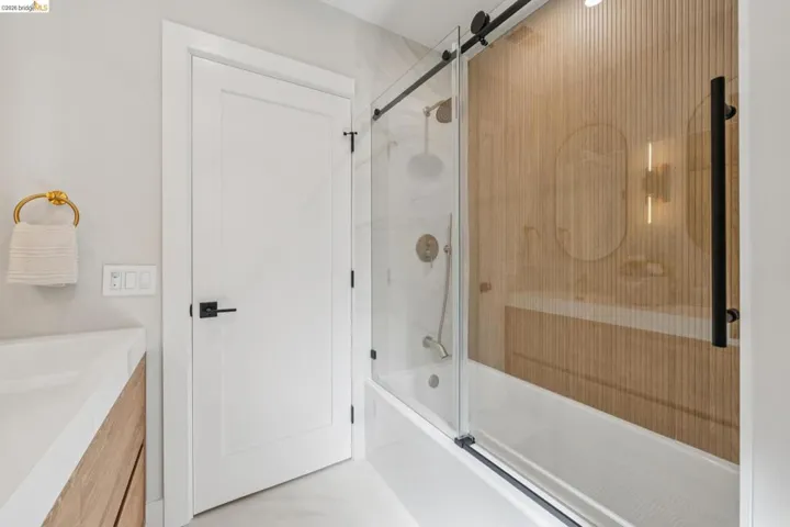 Full bath featuring vanity and enclosed tub / shower combo