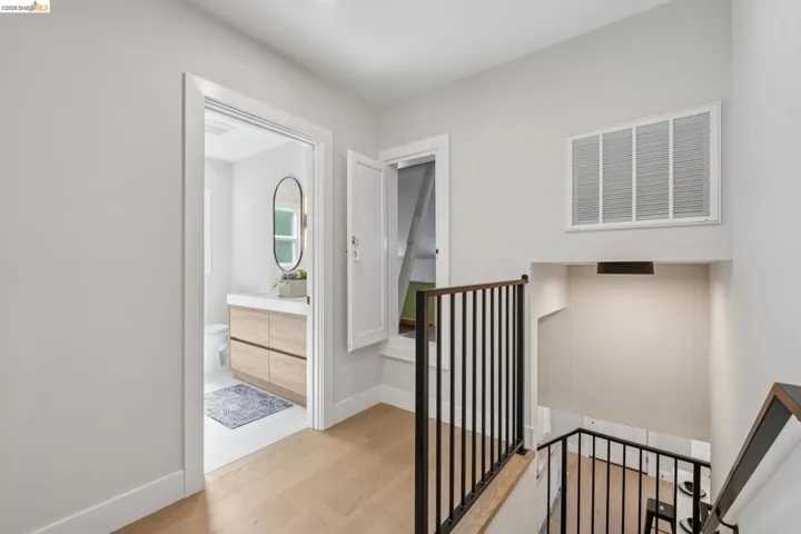 Hallway with an upstairs landing and light wood-style floors