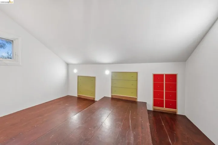 Bonus room featuring lofted ceiling and dark wood finished floors