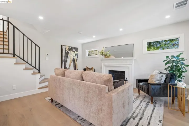Living area with light wood finished floors, a fireplace, and recessed lighting