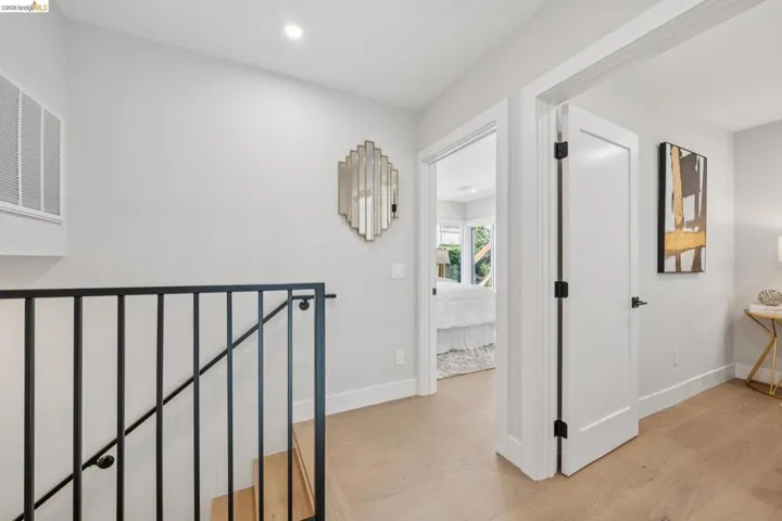 Corridor featuring light wood-style flooring, recessed lighting, and an upstairs landing