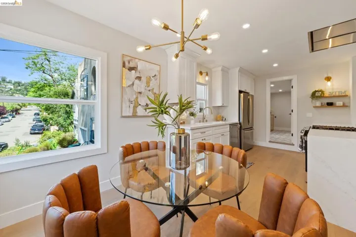 Dining room with light wood-style floors and suspended lighting