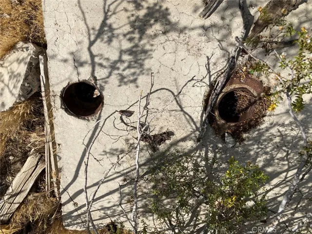 Two pipes in the cement slab.  Maybe there is an old well there?
