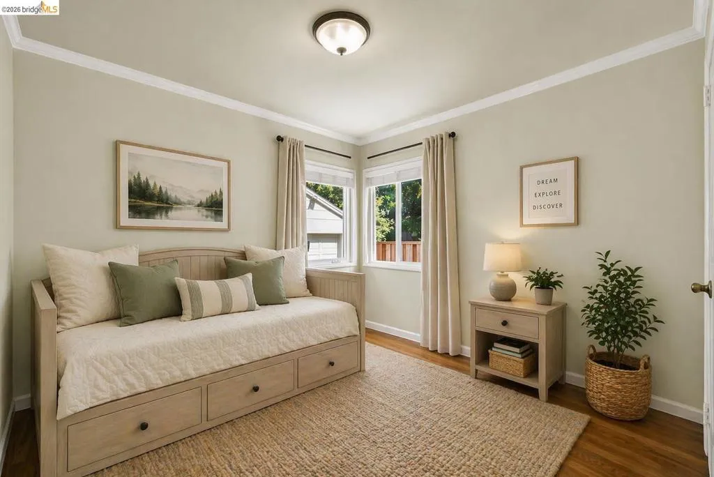 Bedroom with ornamental molding and wood finished floors
