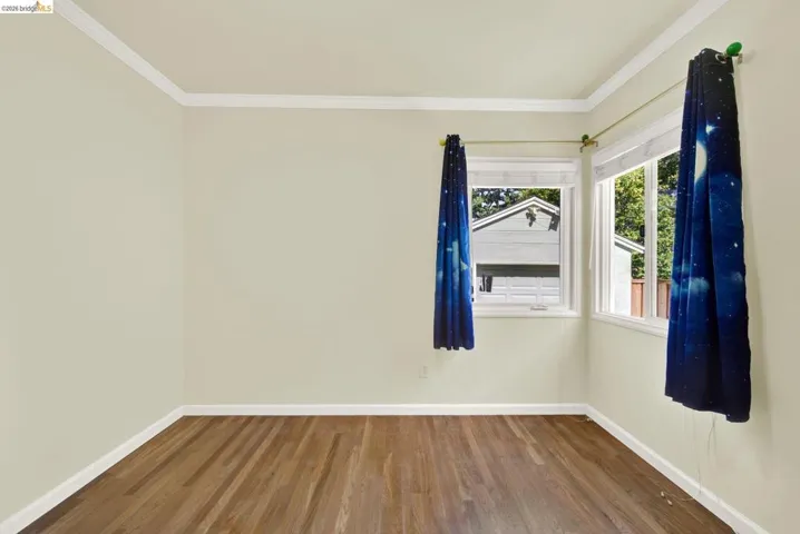 Empty room with wood finished floors and ornamental molding