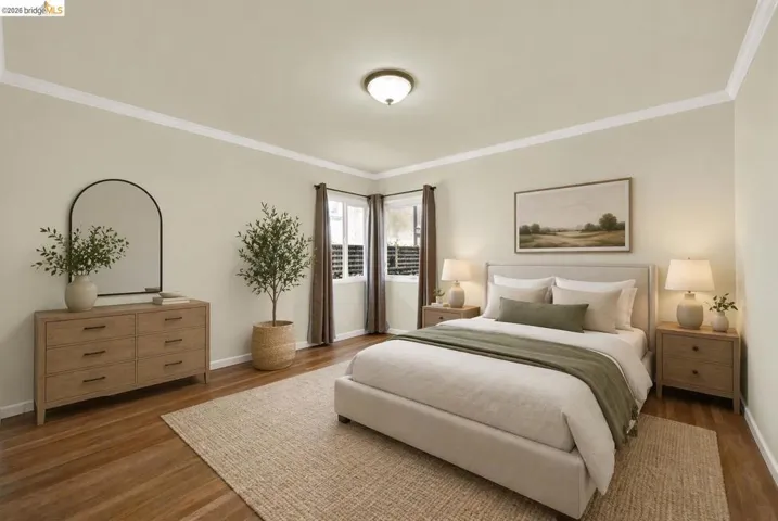 Bedroom featuring crown molding and dark wood finished floors