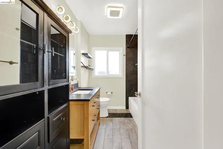 Bathroom featuring vanity, tub / shower combination, and wood tiled floors