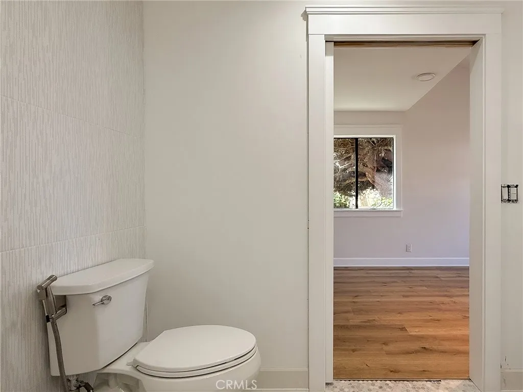 Sliding door leads to a roll-in tiled bathroom designed for ease of access.