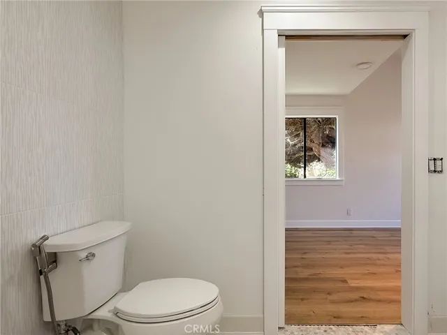 Sliding door leads to a roll-in tiled bathroom designed for ease of access.
