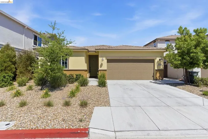 Single-story residence featuring a two-tone stucco facade, concrete tile roof, and an attached two-car garage