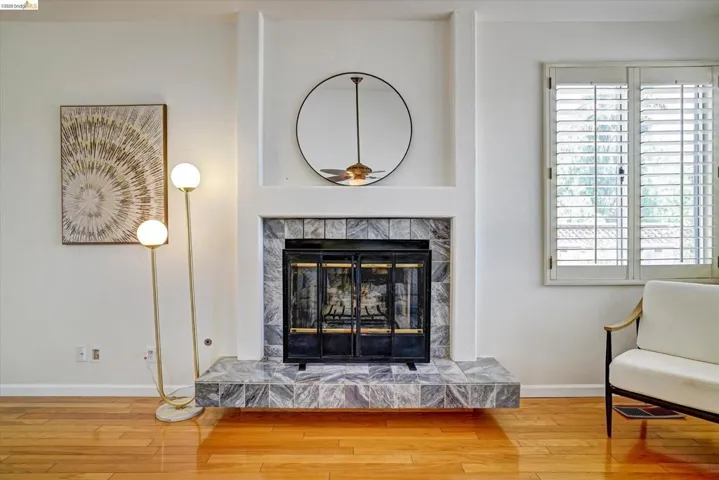Fireplace featuring a tiled surround and hearth, with a metal fire screen