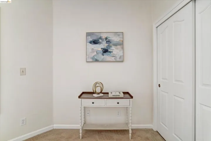 Neutral wall finishes with a decorative console table and a bi-fold closet door