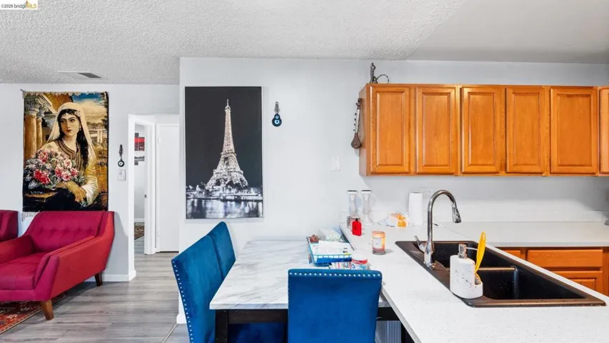 Kitchen featuring wood finish cabinets, a peninsula, a textured ceiling, a breakfast bar area, and wood finished floors