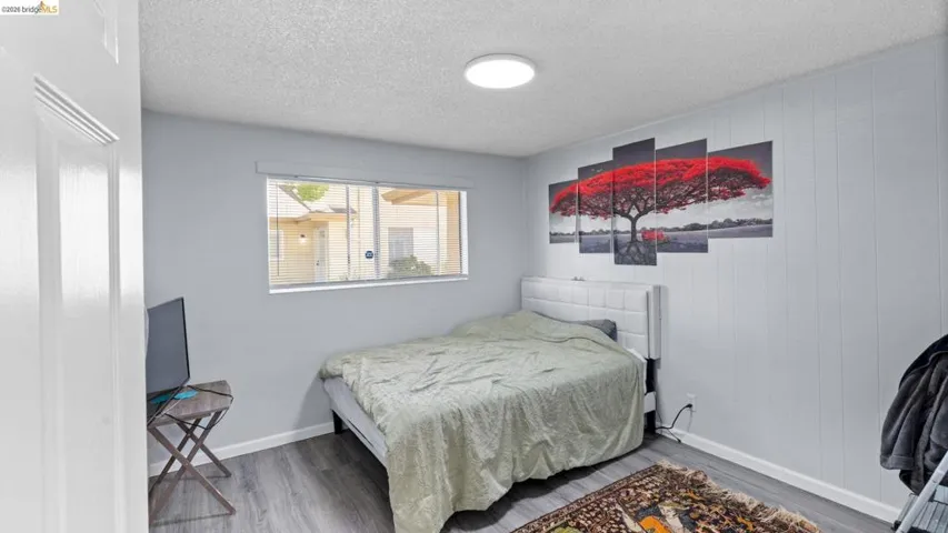 Bedroom with wood finished floors and a textured ceiling