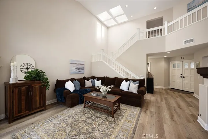 The living room features a skylight, beautiful vinyl flooring, and fresh paint.
