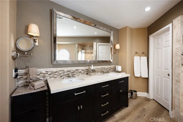 There is a Restoration Hardware vanity, Crema Marfil marble, and tile finishes in the primary bathroom.