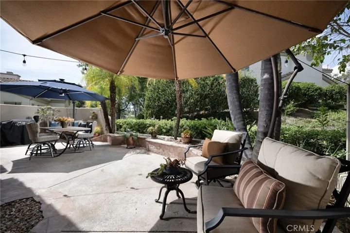 Step outside to a private backyard retreat with hardscape and lush tropical landscaping.