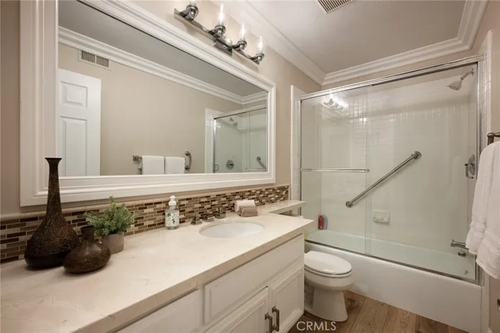 Guest bathroom located upstairs with Crema Marfil marble, tile finishes, shower and bathtub.