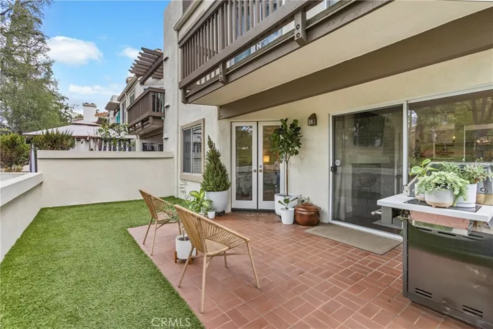 Large backyard with brick patio and low maintenance artificial turf