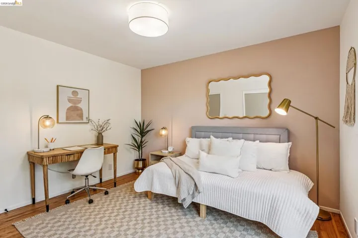 Bedroom featuring wood finished floors and an office area