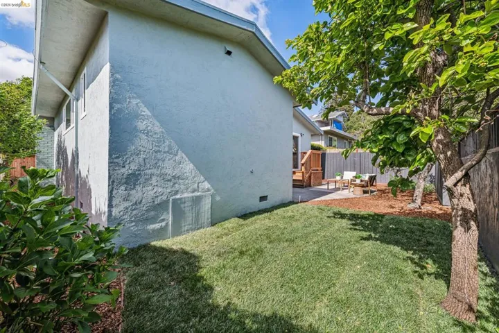 View of side of property featuring a patio, a fenced backyard, stucco siding, and crawl space