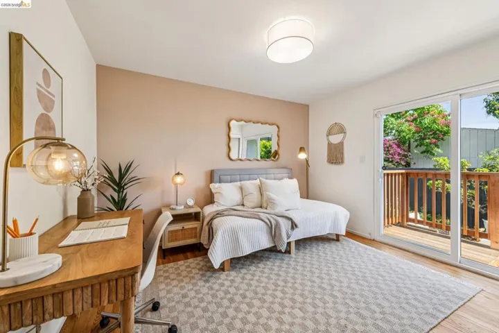 Bedroom featuring access to exterior, an office area, and wood finished floors