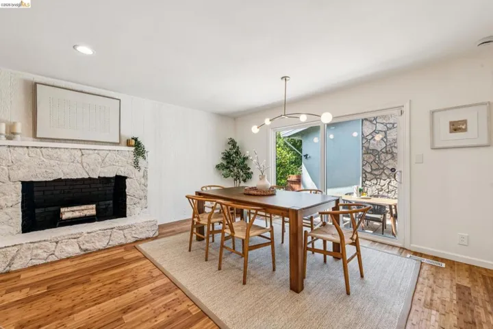 Dining room featuring a fireplace, light wood-style floors, and a chandelier