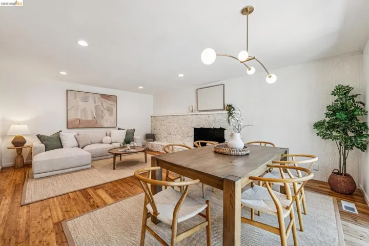 Dining space featuring light wood-style flooring, a fireplace, and recessed lighting