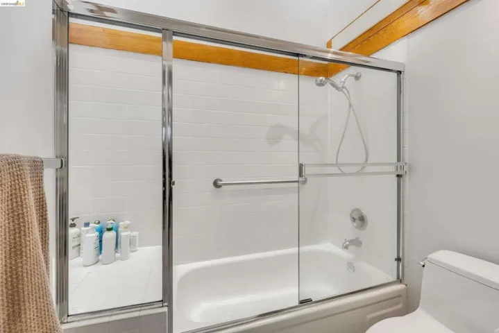 Full bathroom featuring enclosed tub / shower combo and toilet