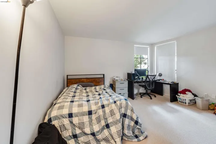 Carpeted bedroom with a desk