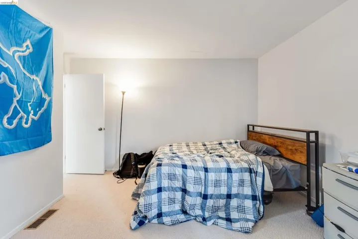Bedroom featuring light carpet and baseboards