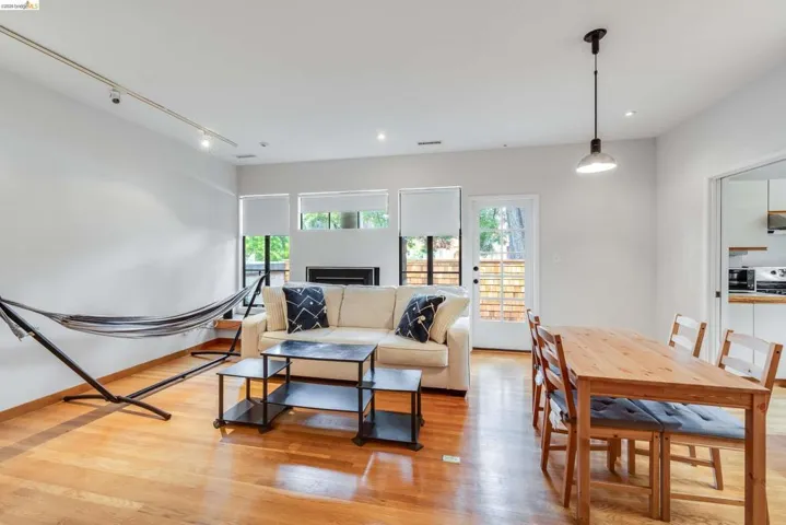Living area featuring light wood-style flooring, track lighting, and healthy amount of natural light