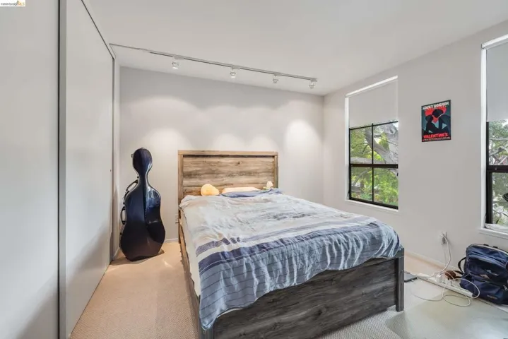Bedroom featuring light colored carpet and rail lighting